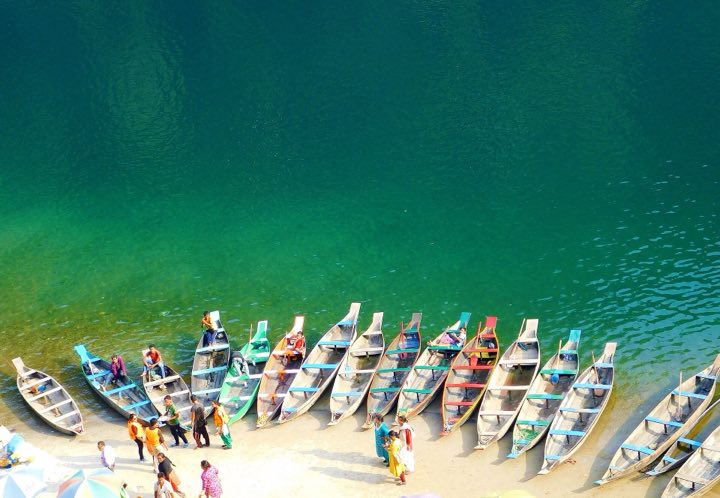 Colourful wooden boats lined up on the clear green Umngot river at Dawki